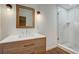 Modern bathroom with wooden vanity, glass-enclosed shower, and stylish lighting fixtures at 3159 Nursery Se Rd, Smyrna, GA 30082