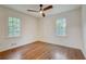 Bright bedroom with hardwood floors, two windows, a ceiling fan, and ample natural light at 3159 Nursery Se Rd, Smyrna, GA 30082