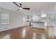Open concept living space boasts hardwood floors, a ceiling fan, and a view into the kitchen with white cabinets at 3159 Nursery Se Rd, Smyrna, GA 30082