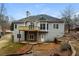 Expansive home exterior showcasing a wooden deck, large windows, and lush surrounding landscape at 5055 Hickory Hills Dr, Woodstock, GA 30188