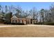 Charming single-story home with a well-manicured lawn, brick facade, and mature trees at 5055 Hickory Hills Dr, Woodstock, GA 30188