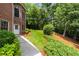 Brick home with a lush green backyard and a sidewalk leading to the side entrance of the house at 1655 Arrowhead Ne Trl, Atlanta, GA 30345