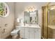 Well-lit bathroom featuring a glass-enclosed shower, white cabinets, and a round window at 1655 Arrowhead Ne Trl, Atlanta, GA 30345