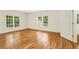 Bedroom featuring gleaming hardwood floors, with two windows and an open door to a closet or bathroom at 1655 Arrowhead Ne Trl, Atlanta, GA 30345