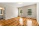 Empty room featuring hardwood floors, two windows and an entry to the bathroom at 1655 Arrowhead Ne Trl, Atlanta, GA 30345