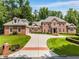 Stately brick home featuring a circular driveway, attached garage, and lush landscaping at 1655 Arrowhead Ne Trl, Atlanta, GA 30345