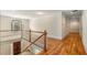 Second floor hallway with wood floors, white railings and natural light from large window at 1655 Arrowhead Ne Trl, Atlanta, GA 30345