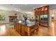 Open kitchen with granite countertops, a large island, stainless steel appliances, and an adjacent dining area with a fireplace at 1655 Arrowhead Ne Trl, Atlanta, GA 30345
