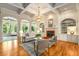 Elegant living room with coffered ceiling, fireplace, built-ins, and arched openings to the sunroom, seamlessly blending indoor and outdoor spaces at 1655 Arrowhead Ne Trl, Atlanta, GA 30345