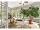 Light-filled sunroom with slate floors, multiple windows overlooking the lush landscape, and a beautiful potted tree at 1655 Arrowhead Ne Trl, Atlanta, GA 30345