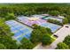 Aerial view of multiple tennis courts and stadium seating surrounded by mature trees at 1655 Arrowhead Ne Trl, Atlanta, GA 30345