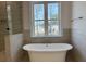 Freestanding tub in a modern bathroom with a large window view and custom tiled shower at 1114 Low Water Crossing, Acworth, GA 30101