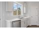 Kitchen sink and dishwasher with white cabinets and herringbone backsplash at 3653 Willingham Sw Run, Marietta, GA 30008