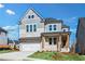 Charming two-story home featuring a brick facade, inviting front porch, and a two-car garage at 3025 Sunset Pass, Canton, GA 30114