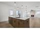 Open kitchen with a central island, stainless steel appliances, and views of the living area with a fireplace at 3025 Sunset Pass, Canton, GA 30114