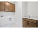 Laundry room with white walls, wooden cabinets, a sink, and a laundry water hookup at 3025 Sunset Pass, Canton, GA 30114