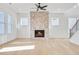 Bright and airy living room features a brick fireplace, large windows, and open access to the staircase at 3025 Sunset Pass, Canton, GA 30114