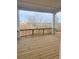 Covered back patio with wooden flooring overlooking wooded surroundings and distant homes at 3025 Sunset Pass, Canton, GA 30114