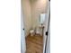 This powder room features a pedestal sink with an oval mirror and a hardwood floor at 3025 Sunset Pass, Canton, GA 30114