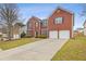 Brick two-story house with a two-car garage and landscaping at 1123 Diamond Xing, Mcdonough, GA 30252