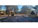 Wide shot of a blacktop driveway leading to a home's exterior, framed by mature trees at 358 Gold Mine Rd, Dallas, GA 30157