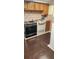 Galley kitchen features white appliances with stone backsplash and wooden cabinets at 358 Gold Mine Rd, Dallas, GA 30157