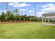 Large backyard with lush lawn, landscaping, and privacy fence under a sunny sky at 128 Laurel Farms Ln, Dallas, GA 30157