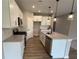 Bright kitchen features stainless appliances, stone countertops and a central island with a sink and stylish pendant lighting at 128 Laurel Farms Ln, Dallas, GA 30157