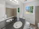 Well-lit bathroom with dual sinks, a window, and a shower-tub combination at 2713 Laurel View Dr, Snellville, GA 30039
