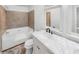 Modern bathroom featuring a tub and vanity with a marble countertop and dual mirrors at 2713 Laurel View Dr, Snellville, GA 30039