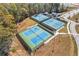 An aerial view of tennis courts with benches, lights, and green surroundings at 6670 Benchwood Path, Cumming, GA 30028