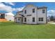 A well maintained backyard with a sprawling green lawn on a white two story home at 6670 Benchwood Path, Cumming, GA 30028