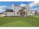 A well maintained backyard with a covered porch on a white two story home with a sprawling green lawn at 6670 Benchwood Path, Cumming, GA 30028