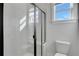 Bathroom featuring a glass shower, white tiles, and a toilet beneath a window at 6670 Benchwood Path, Cumming, GA 30028