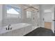 Modern bathroom featuring a glass-enclosed shower, soaking tub, and tiled walls at 6670 Benchwood Path, Cumming, GA 30028