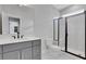 Bathroom with modern shower, gray cabinets, white countertop, and ample natural light at 6670 Benchwood Path, Cumming, GA 30028