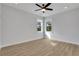 Bedroom with a modern ceiling fan, two windows, and light-colored flooring at 6670 Benchwood Path, Cumming, GA 30028