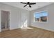 Bedroom with hardwood flooring, ceiling fan, and large window offering natural light at 6670 Benchwood Path, Cumming, GA 30028