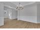Spacious dining room with hardwood floors, a modern chandelier, and wainscoting at 6670 Benchwood Path, Cumming, GA 30028