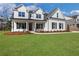 Inviting home with a red front door, well-kept lawn, and classic architectural details at 6670 Benchwood Path, Cumming, GA 30028
