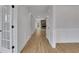 Bright hallway with hardwood floors leading to an open living space with a stone fireplace at 6670 Benchwood Path, Cumming, GA 30028