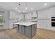 Open kitchen featuring an island, white cabinets, stainless steel appliances, and modern pendant lights at 6670 Benchwood Path, Cumming, GA 30028