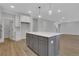 A large kitchen island with gray cabinets and white countertops, opens to living area at 6670 Benchwood Path, Cumming, GA 30028