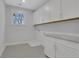 Functional laundry room with white cabinets and a granite countertop at 6670 Benchwood Path, Cumming, GA 30028