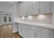 Bright pantry with white cabinets, light countertops, modern backsplash, and view of a windowed door to backyard at 6670 Benchwood Path, Cumming, GA 30028