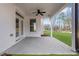 Covered outdoor patio with ceiling fan, offering a relaxing space with views of the landscaped yard at 6670 Benchwood Path, Cumming, GA 30028