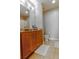 Bathroom featuring granite countertops, wood cabinets, a mirror, and tile floors at 171 Auburn Ave # 329, Atlanta, GA 30303