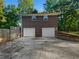 Two-car garage with white doors and driveway, alongside wooden fence and landscaping at 3371 Vandiver Dr, Marietta, GA 30066