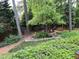 Sloping backyard with a stream, rock wall and mature landscaping at 5741 Wolf Laurel, Lilburn, GA 30047