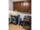 Efficient laundry room features modern washer and dryer units and dark cabinets for a seamless laundry experience at 5741 Wolf Laurel, Lilburn, GA 30047